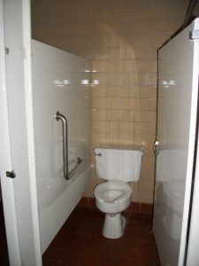 Undersized restroom stall with inswing door and no rear grab bar