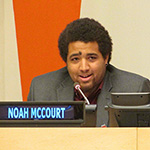 Noah McCourt smiling and speaking into a microphone