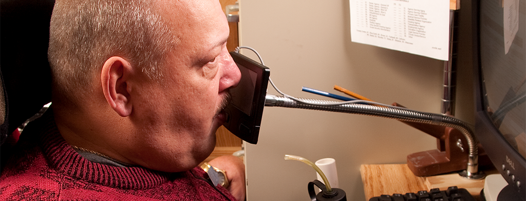 Man operating a trackpad with his nose