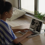 Woman in her home office sitting in front of her laptop.