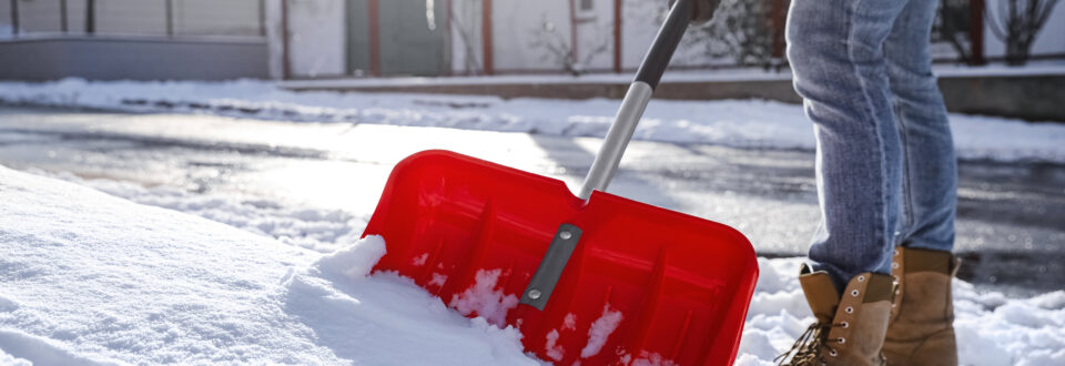 Closeup of a person shoveling snow off a sidewalk
