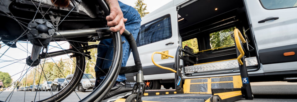 Person in a wheelchair getting on the lift of an accessible van