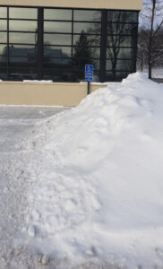 A business's disability parking place obstructed by snow.