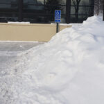 A business's disability parking place obstructed by snow.