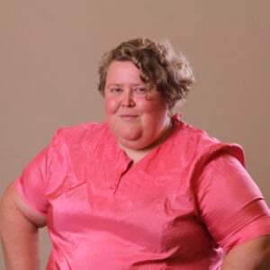 Alison Bergblom Johnson, a white woman with rosy cheeks wearing a rosier blouse smiles at the camera