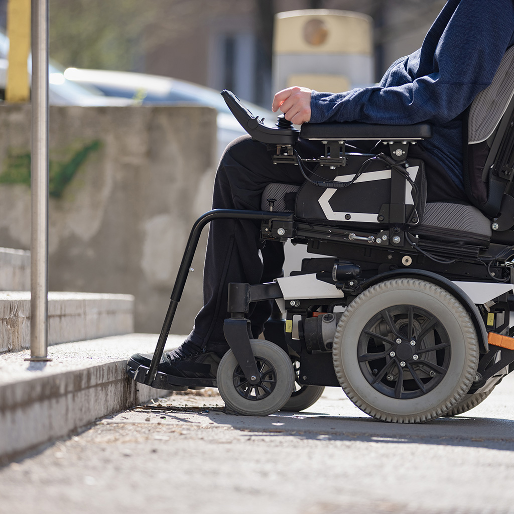 Person in a power wheelchair stopped at a set of steps