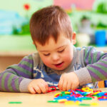 Boy with Down Syndrome playing in kindergarten