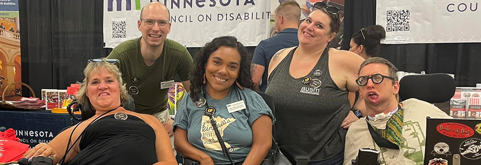 Booth visitors and MCD staff at the State Fair. Three of the people use wheelchairs.