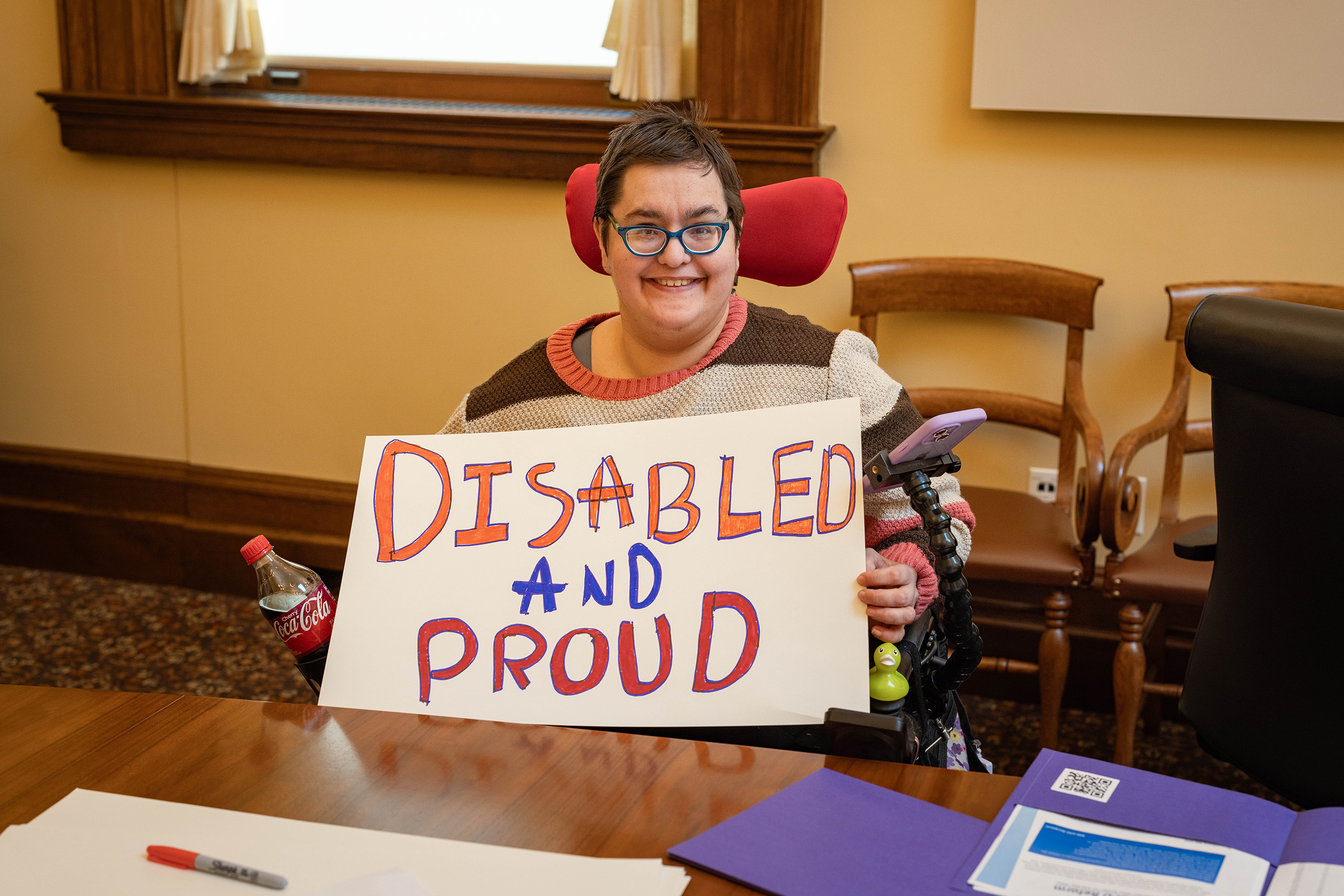 Rally participant in a wheelchair holding a sign that reads, "Disabled and Proud"